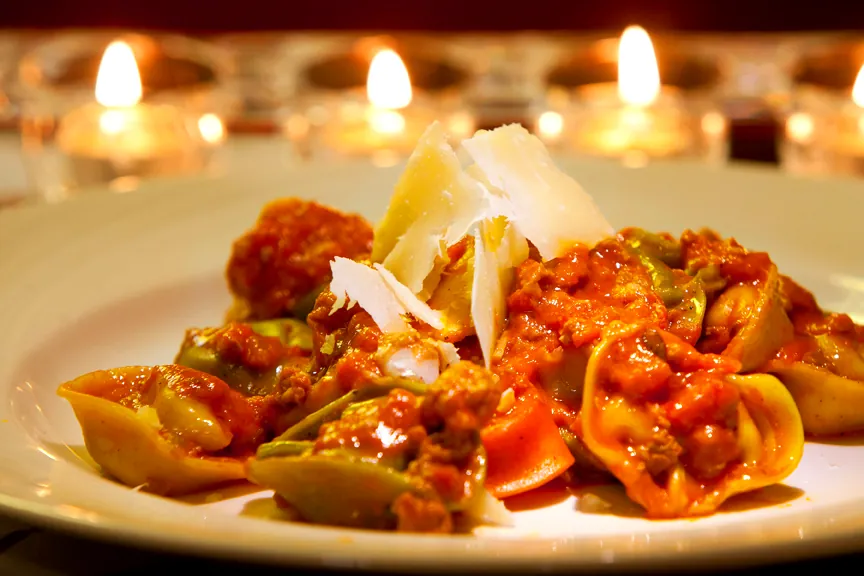 Warm candlelit meal: fresh pasta served during a Diner Santé experience