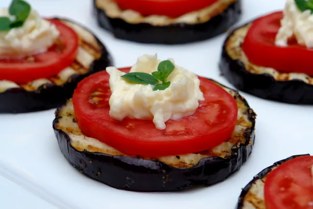 Vegetarian menu: grilled eggplant topped with fresh tomatoes and cheese